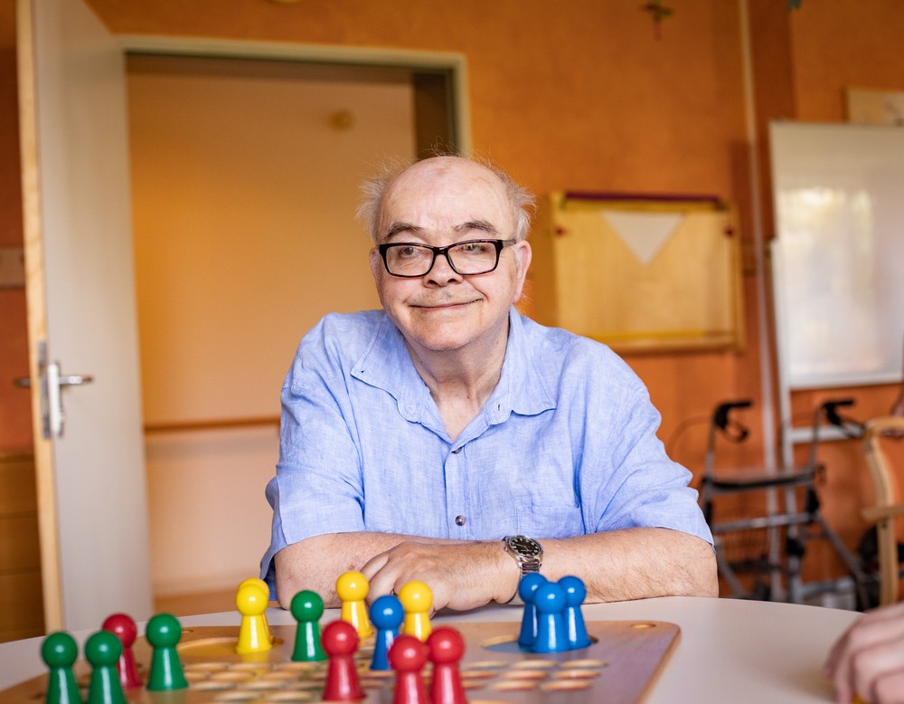 Ein Bewohner vor dem Brettspiel "Mensch-ägere-Dich-nicht". Ein Bewohner vor dem Brettspiel "Mensch-ägere-Dich-nicht".